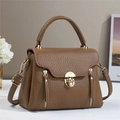 Close-up of brown litchi pattern leather handbag with golden metal twist lock and zippers - Earthy Yellow