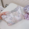 Detail der Kosmetiktasche aus Jacquard-Satin mit Rosenmuster und Markenetikett - Hellviolette Rosa Rose