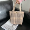 Close-up of retro plaid canvas handbag with textured fabric straps and metal snap button - Haze Brown