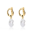 Macro detail of geometric golden metal ring with irregular freshwater pearl drops - Gold Twisted Ring Leverback with Baroque Pearl