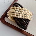 Dettaglio del bracciale multistrato in perline di legno di cocco su vassoio di legno - Caffè & Bianco Crema