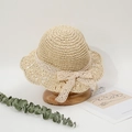Dettaglio del cappello di paglia intrecciato con pizzo delicato e fiocco su base in legno - 50-52CM / Beige