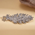 Detailed macro view of silver feather brooch with sparkling rhinestones and metal link - Silver