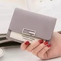 Detalle de mini cartera bicolor morada y beige con hebilla plateada y texto - Violeta Claro