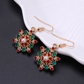 Vue macro de boucles d'oreilles flocon avec strass rouges verts et perle blanche - Flocon de Neige Rouge Vert
