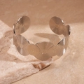 Dettaglio di bracciale rigido argento con motivi geometrici a spirale su sfondo di pietra - Piccolo / Polsino a onde aperte / Argento
