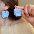 Détail de boucles d'oreilles fleurs bleues mates portées pour montrer la taille - Style Fleur Huile d'Égouttage Bleu Mat