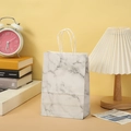 Detail of marble pattern gift bag with white rope handles in a cozy home setting - Grey White Marble 15x11x6cm