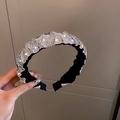 Sparkling silver rhinestone headband with black fabric twist design held by hand - Black Velvet Rhinestone Headband