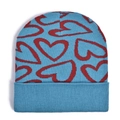 Close-up of light blue knit beanie featuring red heart patterns and ribbed cuff detail - Blue Background Red Hearts