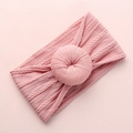Detail of pink knitted baby headband with soft cable texture and central round knot ball - Deep Pink