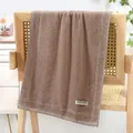 Thick brown cotton towel with slow life label and grey stripes on a wooden surface - Plain Stripe - Brown