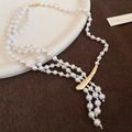 Detail of multi-layer pearl necklace with golden charm on beige plate and fur background - 92# Necklace - Glass Pearl Beaded Multi-layer Asymmetric