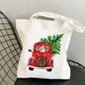White canvas tote bag featuring Christmas corgi print on a black iron chair - C4-Christmas Truck Corgi