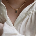 Elegante goldene Schlangenkette mit schwarzem rechteckigem Anhänger auf weißer Spitze - Gold + Schwarzer Zirkonia