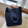 Detailansicht der blauen Denim-Tasche mit bunten Fasern und simple wish Etikett - Denim-Blau