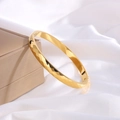 Detailed view of golden hammered titanium steel bracelet on white silk luxury background - Gold