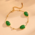 Dettaglio di un bracciale placcato oro con pietre ovali verdi e una chiusura a moschettone - Bracciale Verde (A619)
