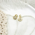 Macro view of gold sun pendants with clear stones on a soft white feather background - Micro Pave Mini Sun