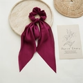 Close-up of deep red satin hair scrunchie with long ribbon bow on marble stone tray - Dark Red