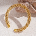 Dettaglio del bracciale dorato con strass e design geometrico su base in pietra grezza - Oro