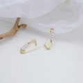 Golden safety pin earrings with white pearls on a clean minimalist display stand - Gold Pearl Safety Pin Earrings