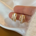 Detail of gold earrings with vertical geometric white shell inlay held by a hand - Gold Three Vertical Line White Rectangle Inset Earring (A43)