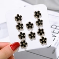 Set of 10 black five-petal flower brooches with gold trim on white display card - Snowflake Style