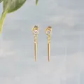 Dettaglio ravvicinato di orecchini a cono placcati oro con marchio S925 e zircone - Stile Bottone Pendente / Oro