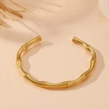 Detalle de brazalete abierto dorado con diseño de bambú y acabado metálico pulido - Pulsera de Bambú (R109) / Dorado