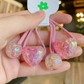 Close-up of four pink elastic hair ties with glittery resin heart and ball pendants - Light Pink