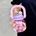 Dettaglio del tappo viola con panda e manico rosa su una borraccia in plastica di grande capacità - 800ML / Rosa