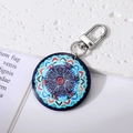 Macro view of blue evil eye mandala pendant keychain with metallic lobster clasp - Red Blue Hands
