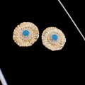 Makroaufnahme von Vintage-Blumenohrsteckern mit blauem Edelstein und goldener Textur - Gold