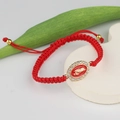 Detail of red handmade woven rope bracelet with gold Virgin Mary oval charm and white crystals - Red