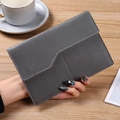 Deep grey minimalist PU leather passport bag with fine lychee texture held in hand - Gray