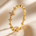 Elegant gold clover ring with zircon inlay set on champagne satin fabric background - Gold Hollow Clover (4071)