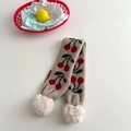 Detail of beige knitted kids scarf with red cherry pattern and faux fur pom-poms - Khaki Cherry