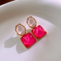 Dettaglio di orecchini geometrici rosso rosa con bordo dorato su vassoio di ceramica bianca - Perno in Argento-Rosso Rosa