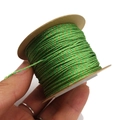 Detail of 1mm grass green cotton cord with gold thread on a brown paper roll - Grass Green