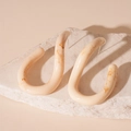 Detail shot of vintage U-shaped resin earrings with cream marble texture on stone - Off-White Resin U-Shaped Studs / Beige (Silver Earring Post)