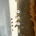 Detail of crystal suncatcher showing golden rings and prism reflecting rainbows - Geometric Circle Cone Style (04)