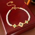 Detailed macro view of gold plated pearl bracelet with blue zircon clover charms - Pearl Beaded Blue Flower Style