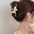 Dettaglio del fermaglio a farfalla color crema con nappine di perle tra i capelli - Stile Nappina Farfalla Rosa