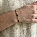 Gold-tone heart bracelet featuring black enamel and sparkling zircon pave crystals - Gold Heart Enamel Drawstring Bracelet (B487)