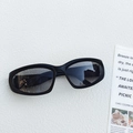 Detail view of black oval sports sunglasses with plastic frames on a textured white surface - Matte Black