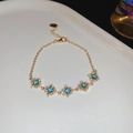 Detailed macro view of gold bracelet featuring square blue zircons with crystal halos - Lobster Clasp Adjustment / Gold Blue Square Zircon