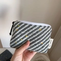 Detail of hand-knit grey striped coin purse with colorful dots and tassel zipper pull - Light Gray