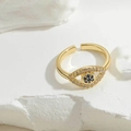 Detailopname van gouden ring met blauwe zirkoon oog en verstelbare open band op steen - Pavé Zirkonia Boze Oog