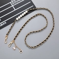 Detail of crossbody chain with black leather, gold metal, pearls and floral charms - Crossbody Chain / Black